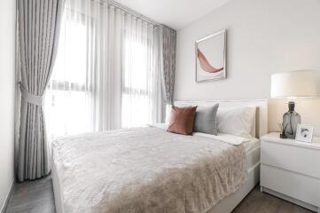 Spacious and bright bedroom with large windows, modern decor, and a comfortable bed