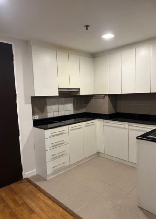 Modern kitchen with white cabinets and black countertops