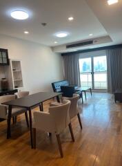 Well-lit living room with dining table and balcony