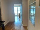 Spacious hallway with wooden flooring and glass block window