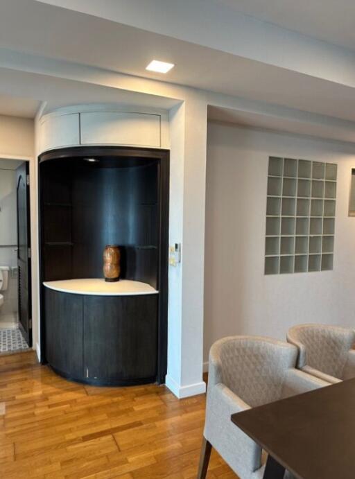 Modern dining area with built-in shelving and adjacent bathroom