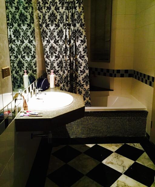 Modern bathroom with intricate tiled design and shower curtain