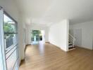 Spacious living room with large windows and wooden flooring