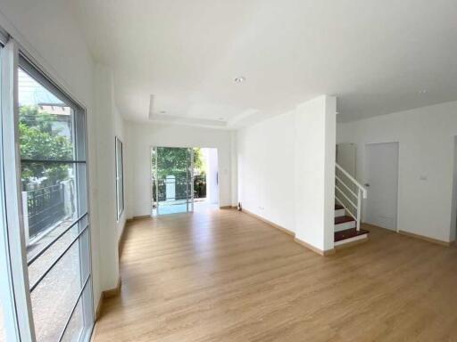 Spacious living room with large windows and wooden flooring