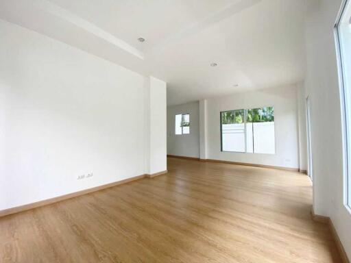 Spacious living area with large windows and wooden flooring