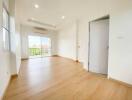 Spacious and bright living room with wooden flooring and large windows