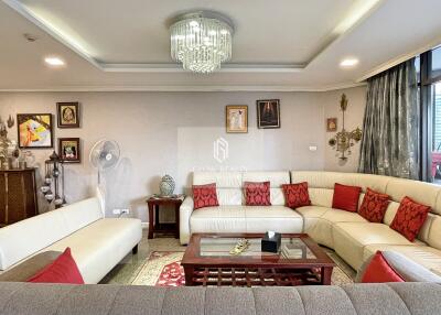 Spacious and elegantly decorated living room with a large L-shaped sofa and chandelier