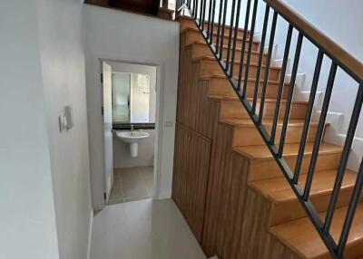Staircase and hallway leading to a bathroom