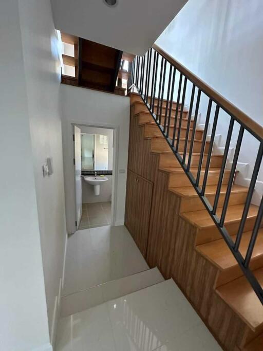 Staircase and hallway leading to a bathroom