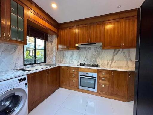 Modern kitchen with wooden cabinetry and marble countertops