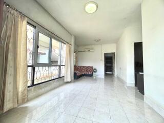 spacious living room with large windows and tiled floor