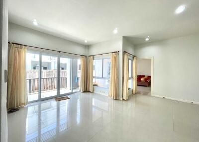 Spacious and well-lit living room with large windows and white tiles