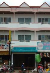 Front view of a three-story building with commercial spaces on the ground floor