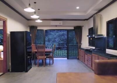 Modern living room and kitchen area with dining table and large windows