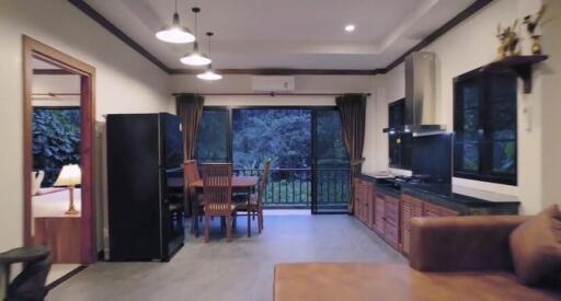 Modern living room and kitchen area with dining table and large windows