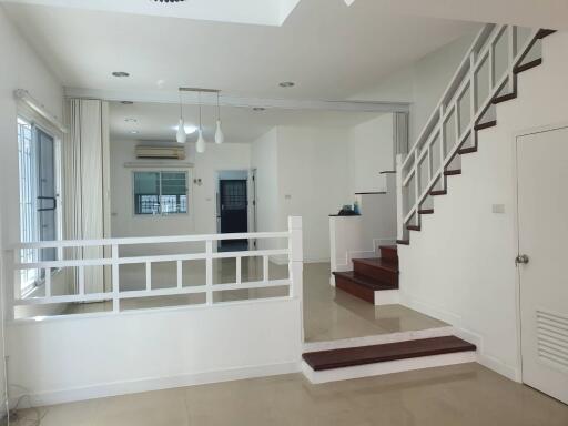 Modern living room with staircase and pendant lighting