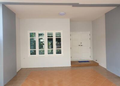 Main entrance with tiled flooring and white double doors