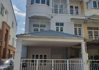 Front view of a residential building with a gated porch and a blue-tiled roof