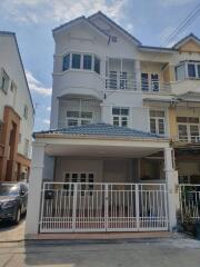 Front view of a residential building with a gated porch and a blue-tiled roof