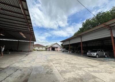 Spacious outdoor area with multiple covered parking spaces and a central building