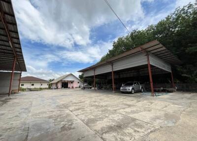 Open covered area with adjacent buildings under a clear sky