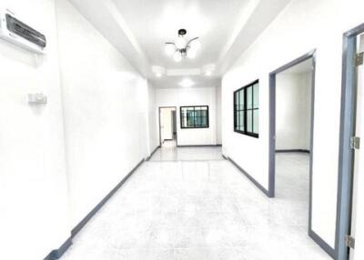 Modern white-walled hallway with doors and windows