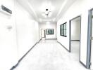 Modern white-walled hallway with doors and windows