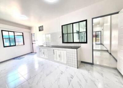 Bright and spacious kitchen with white cabinetry and tiled backsplash