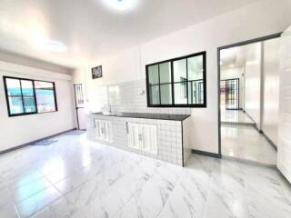 Bright and spacious kitchen with white cabinetry and tiled backsplash