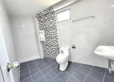 Spacious modern bathroom with tiled flooring and mosaic feature wall