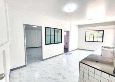 Modern kitchen with white marble flooring and ample natural light