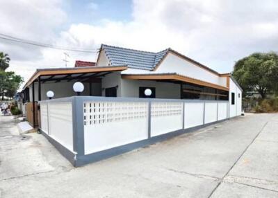 Modern single-story house with white exterior walls and blue roof