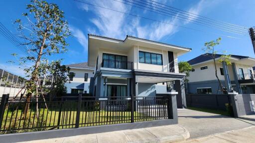 Modern two-story house exterior with a fenced yard