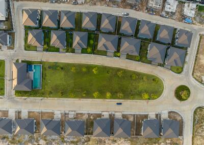 Aerial view of a modern housing development with identical houses and central green area