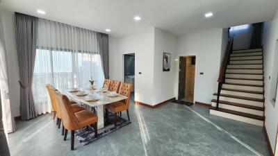 Modern dining area with large windows and staircase