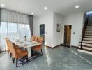 Modern dining area with large windows and staircase