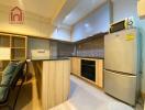 Modern kitchen with wooden cabinets, built-in oven, and refrigerator