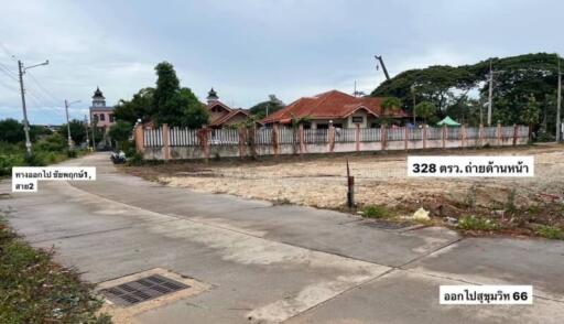 Empty lot with a concrete path and fenced houses in the background