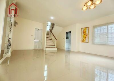 Spacious and well-lit main living area with tiled flooring and staircase