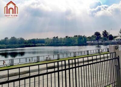 Scenic view of a lake and greenery from behind a gate