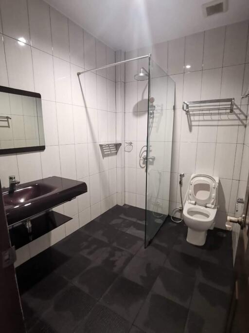 Modern bathroom with glass shower, sink, and toilet