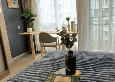 Cozy bedroom with a small desk and chair next to a large window