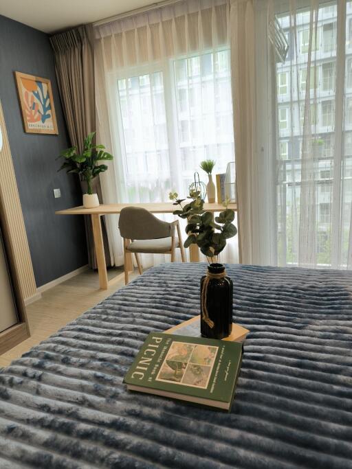 Cozy bedroom with a small desk and chair next to a large window