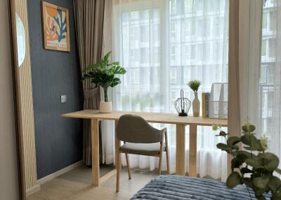 Modern bedroom with a desk, chair, and large window