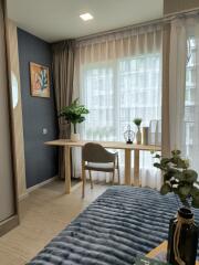 Modern bedroom with a desk, chair, and large window