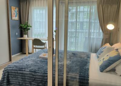 Modern bedroom with large window and blue bedding