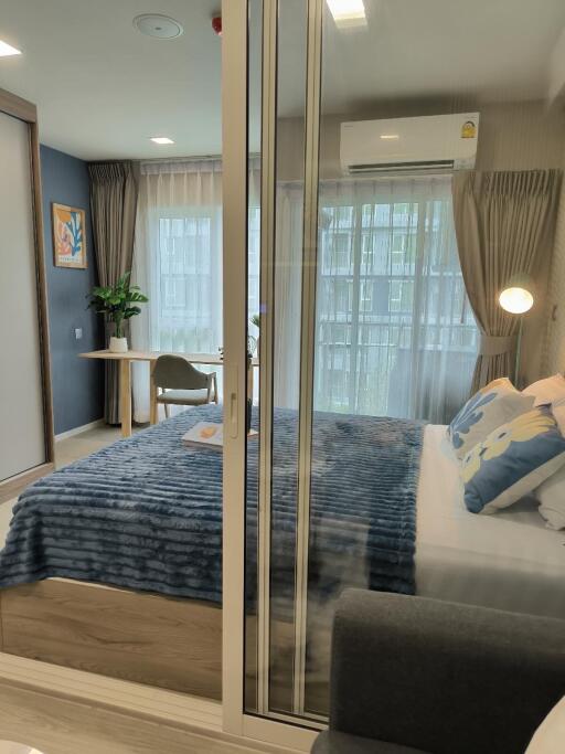 Modern bedroom with large window and blue bedding