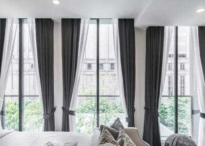 Modern bedroom with large windows and dark curtains