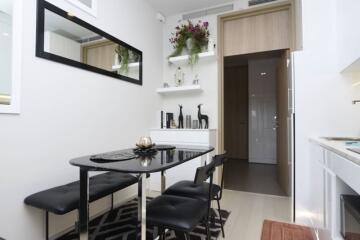 Modern dining area with black table and chairs, decorative shelving, and wall mirror