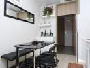 Modern dining area with black table and chairs, decorative shelving, and wall mirror